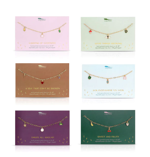 Six gold necklaces on cards with three themed enamel charms on each