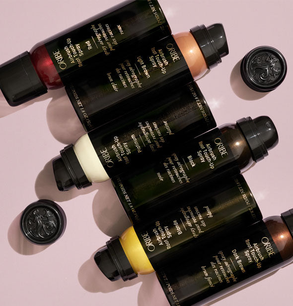 Six cans of Oribe Airbrush Root Touch-Up Spray in Red, Light Brown, Platinum, Black, Blonde, and Dark Brown shades