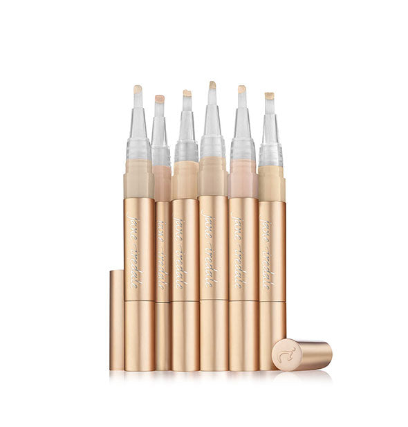 Grouping of six Jane Iredale concealer sticks with lids removed to show applicator tips