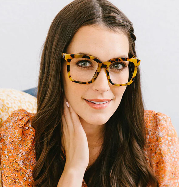 Model wears a square pair of oversized brown tortoise glasses