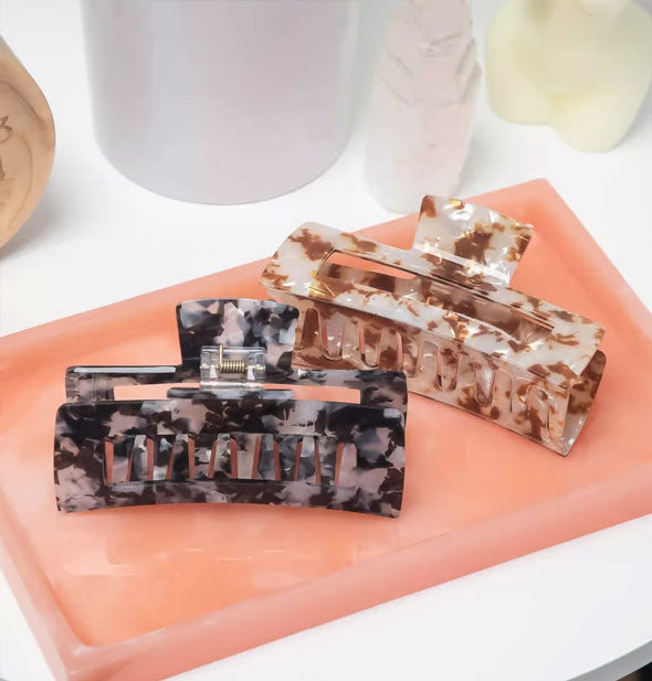 Brown and black marbled claw clips on a rectangular coral tray
