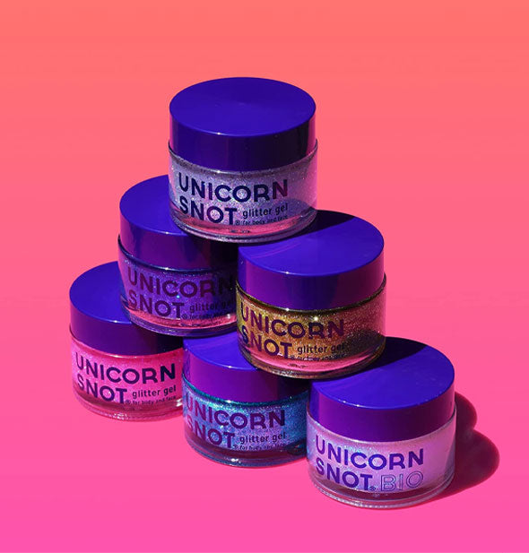 Stacked grouping of six pots of Unicorn Snot Glitter Gel on a pink-to-orange ombre backdrop
