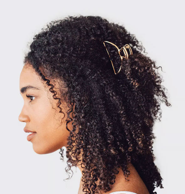 Model wears a rounded metallic gold claw clip