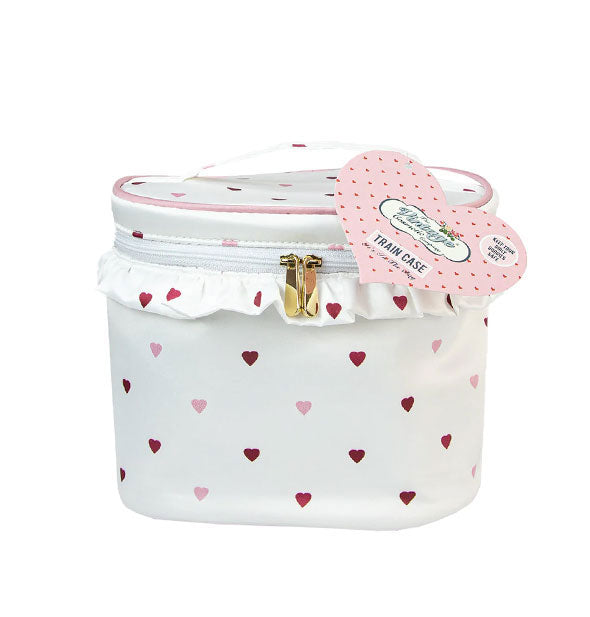 Rounded white zippered train case with top handle, gold hardware, ruffle, and all-over pink and red hearts pattern