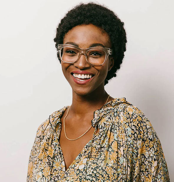 Smiling model wears a pair of clear gray glasses frames