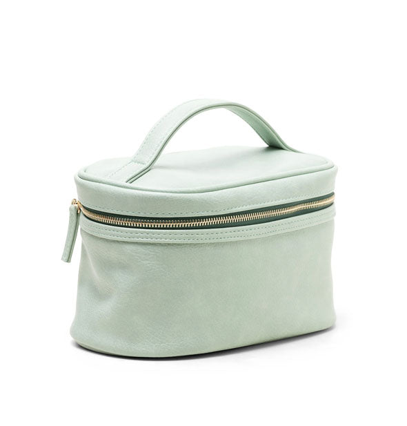 Light green vegan leather travel case with matching top handle and zipper pull tab, dark green zipper tape, and gold zipper hardware