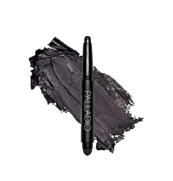 Double-ended Palladio eyeshadow stick with color at one end and black blending sponge at the other rests in front of a color swatch sample in the shade Matte Black