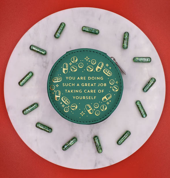 Round dark green pill case on round marble pedestal scattered with glittery green capsules says, "You are doing such a great job taking care of yourself" surrounded by small pill, capsule, and star graphics