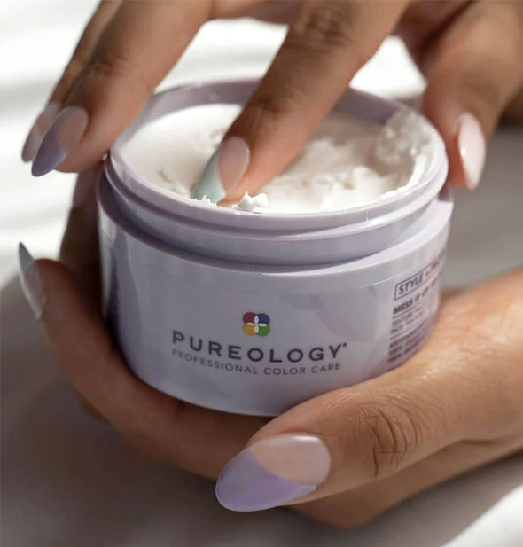 A model's finger dips into a pot of Pureology Style + Protect Mess It Up Texture Paste