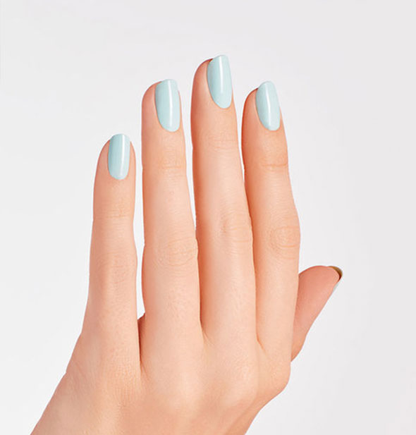 Model's hand wears a light blue-green shade of nail polish