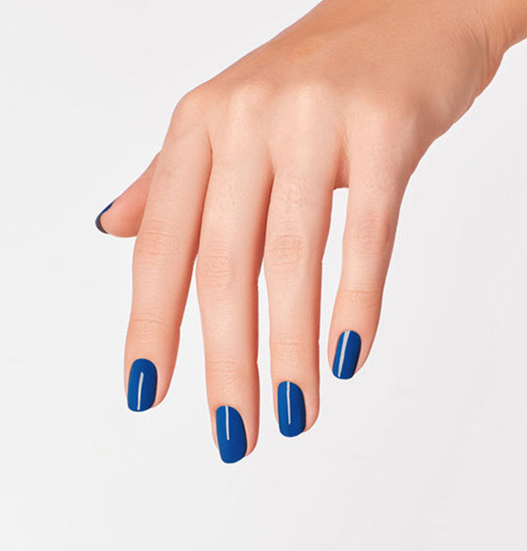 Model's hand wears a deep blue shade of nail polish