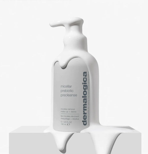 A bottle of Dermalogica Prebiotic PreCleanse is drenched in dripping, creamy white product
