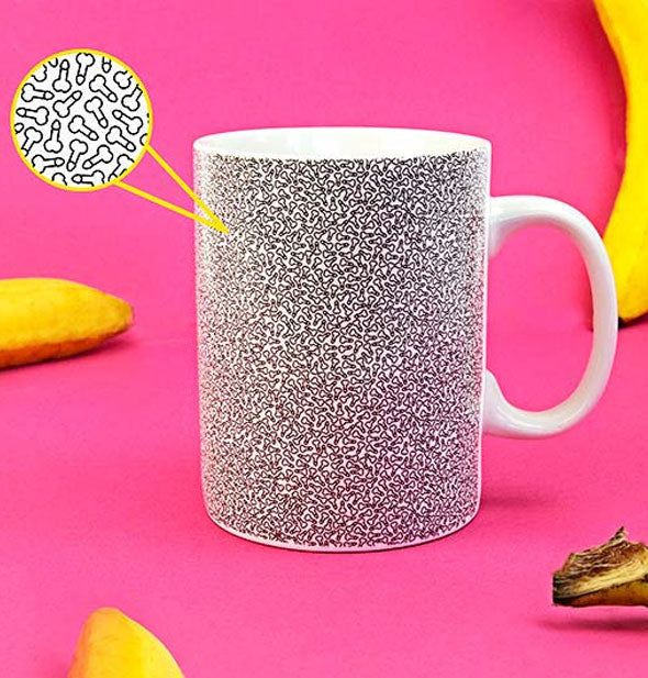 Micro Penis Mug on pink background with yellow bananas features a magnified bubble to show detail of print