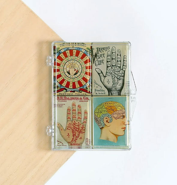 Set of four palmistry-themed rectangular magnets in clear jewel case on white and wood background