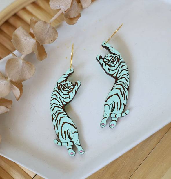 Pair of mint green Tiger Hoop Earrings on white surface