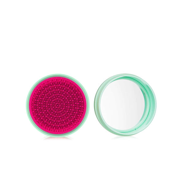 Round mint and raspberry macaron-shaped hairbrush shown open to reveal compact mirror inside
