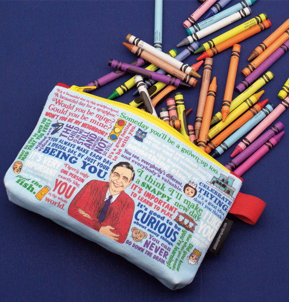 Mister Rogers pouch spills out crayons onto a dark blue surface
