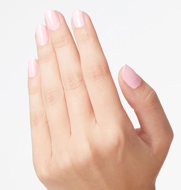 Model's hand wears a light shade of pink nail pollish