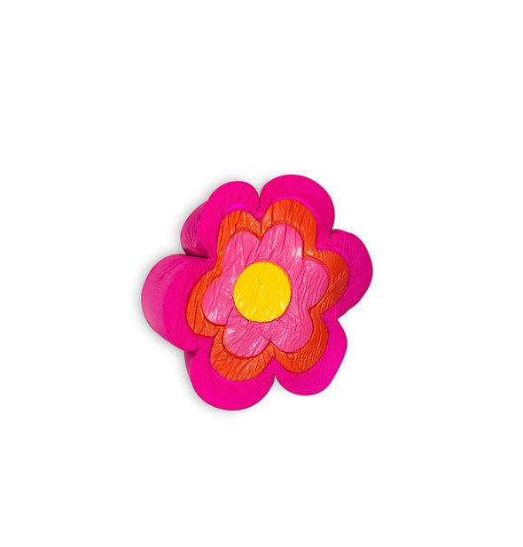 Flower-shaped pink, red, and yellow foam stress toy shown squeezed and distorted
