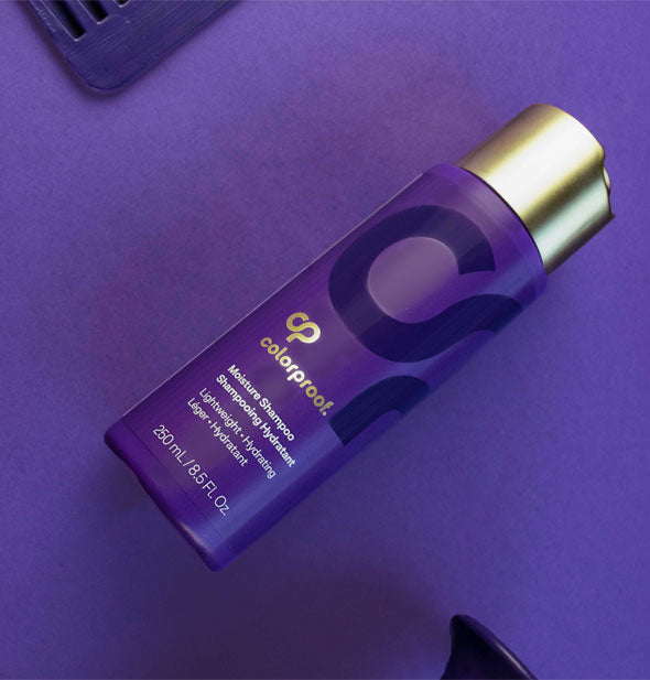 Bottle of ColorProof Moisture Shampoo rests on a purple surface