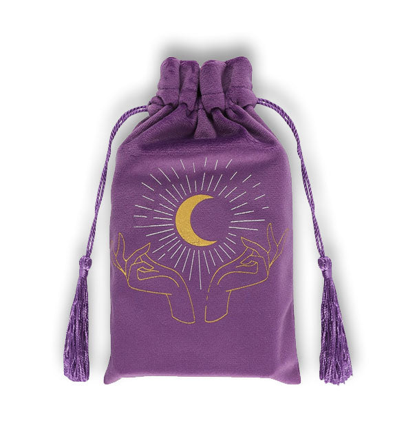 Purple drawstring bag with gold illustration of a glowing crescent moon and hands