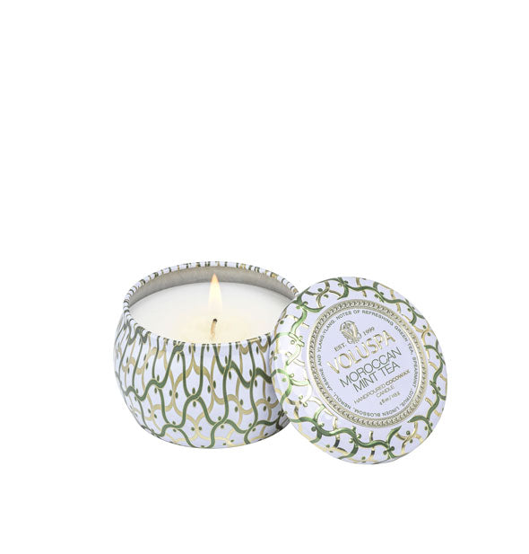 Small decorative Voluspa Moroccan Mint Tea tin candle with one lit wick