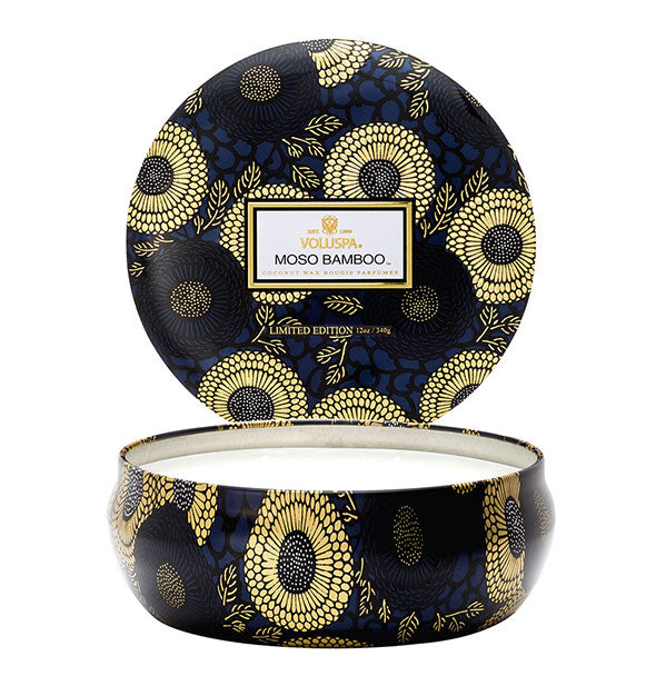 Black, dark blue, and gold metallic floral Moso Bamboo Voluspa candle tin with lid removed