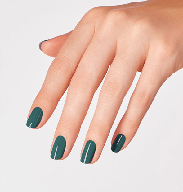 Model's hand wearing dark green nail polish