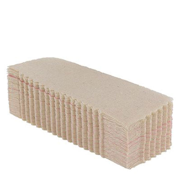 Stack of natural muslin epilating wax strips with zigzagged edges