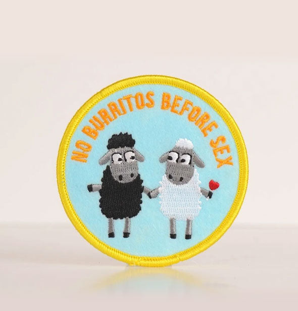 Round embroidered patch with a black sheep and a white sheep on a light blue background says, "No Burritos Before Sex"