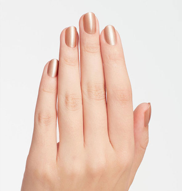 Model's hand wears a rosy brown shimmery nail polish shade