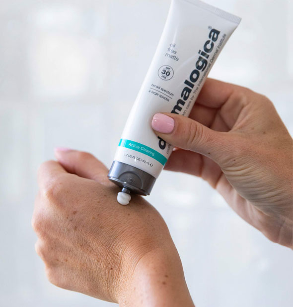 Model applies Dermalogica Active Clearing Oil Free Matte SPF 30 sunscreen to the back of their hand