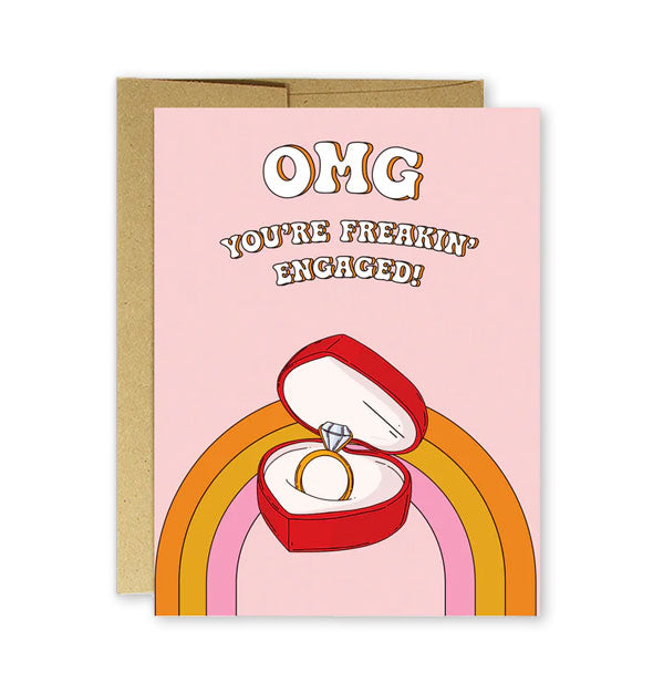 Pink greeting card with rainbow and heart-shaped box with diamond ring illustration says, "OMG you're freakin' engaged!" in white shadowed lettering at the top