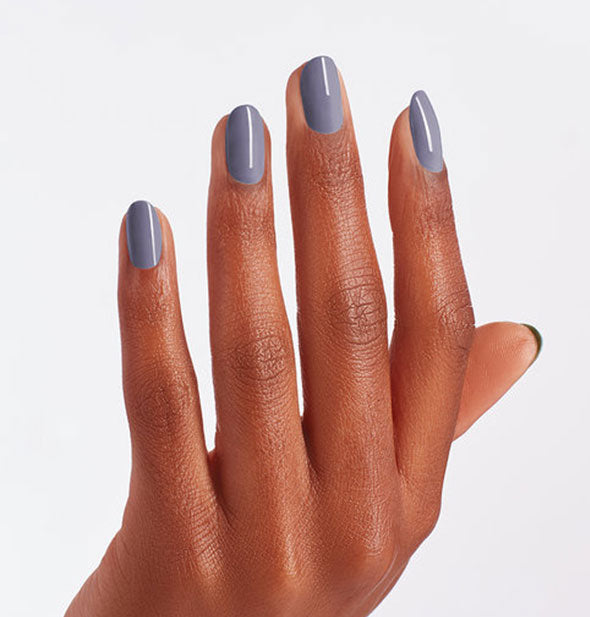 Model's hand wearing blue-gray nail polish