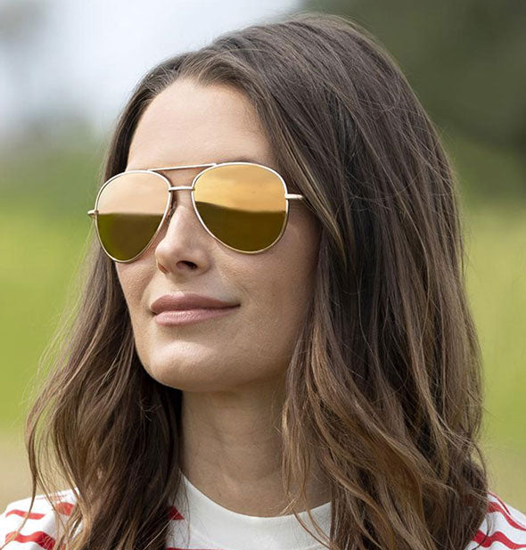 A model wears Peepers Heat Wave Polarized Sunglasses in Orange.