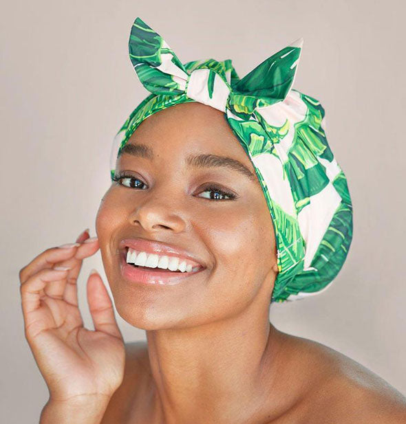 Model wears a palm leaf printed shower cap with bow