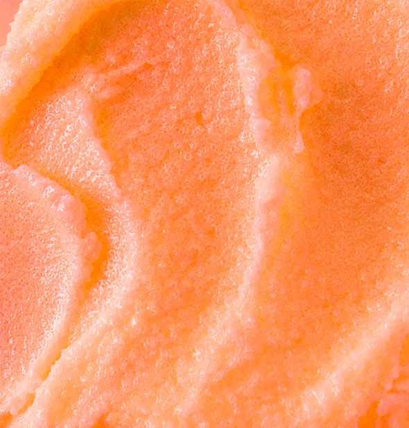 Closeup of Papaya Vanilla Hey, Sugar Body Scrub shows orange coloration and grainy texture
