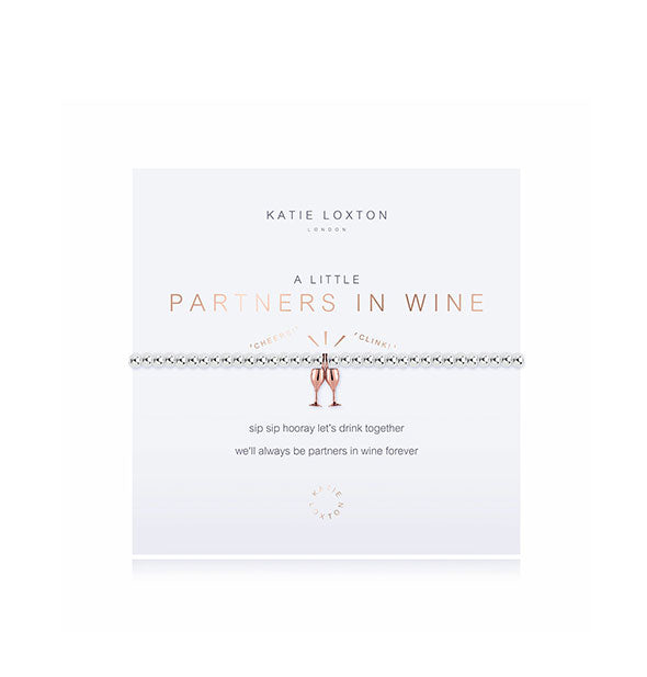 A Little Partners in Wine silver-toned bracelet with rose gold clinking wine glasses charm on white card with metallic design details