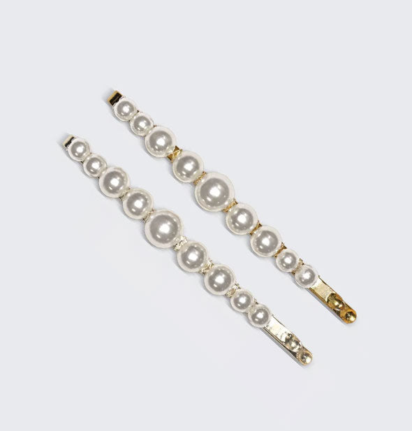 Two gold bobby pins with pearls attached