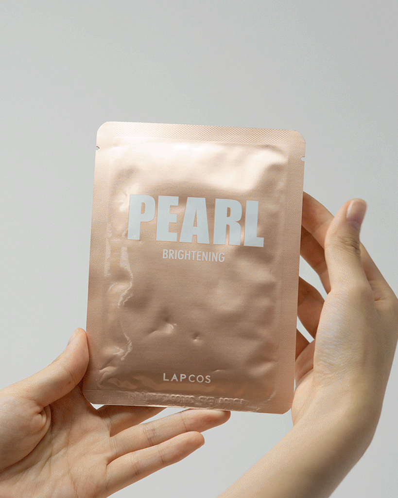 Model's hands remove a Pearl Brightening mask from packaging