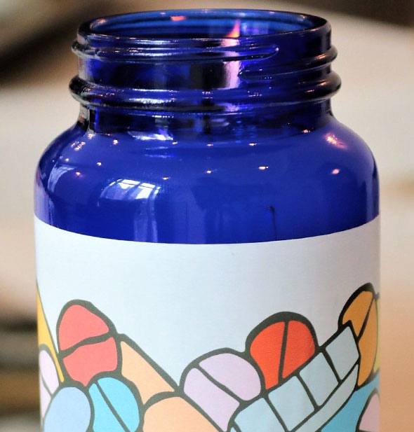 Blue bottle candle with colorful wrap-around pills label