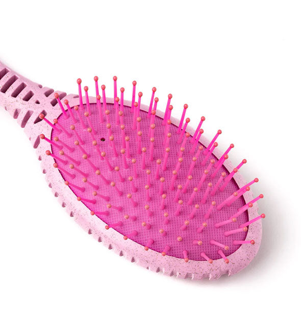 Closeup of a pink cushioned paddle hairbrush head