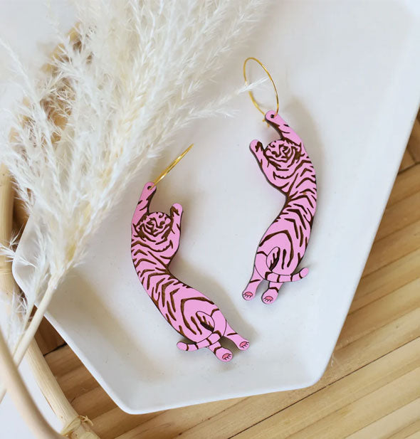Pair of pink Tiger Hoop Earrings on white dish