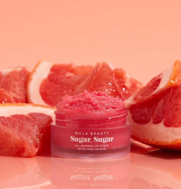 Pot of deep pink NCLA Beauty Sugar, Sugar All Natural Lip Scrub is flanked by slices of grapefruit