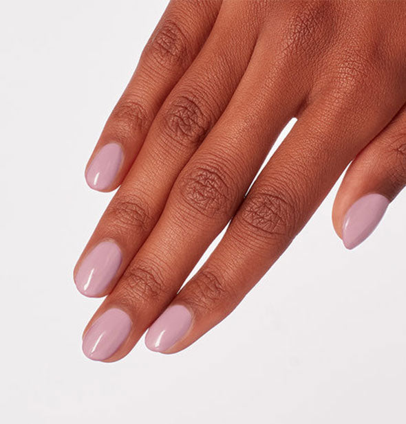 Model's hand wearing a blush pink shade of nail polish
