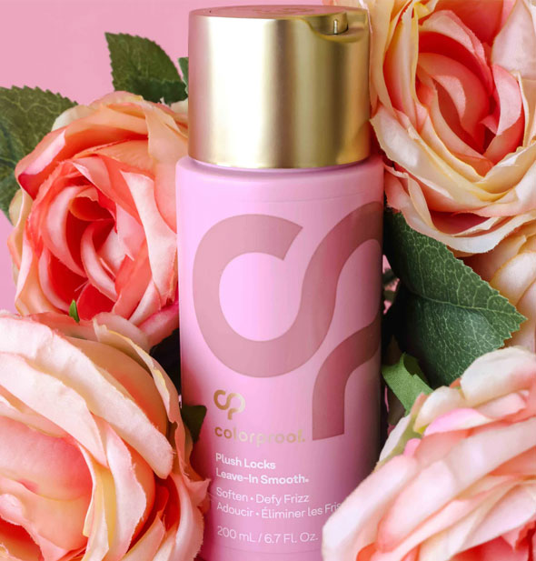 A bottle of ColorProof Plush Locks Leave-In Smooth is nestled among pink roses