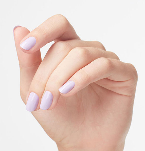 Model's hand wears a pastel purple shade of nail polish