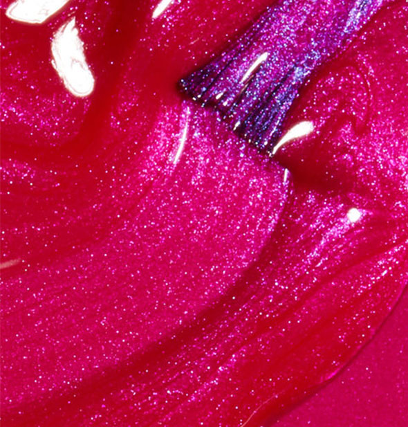 Hot sparkly fuchsia nail polish with brush tip swiped through it