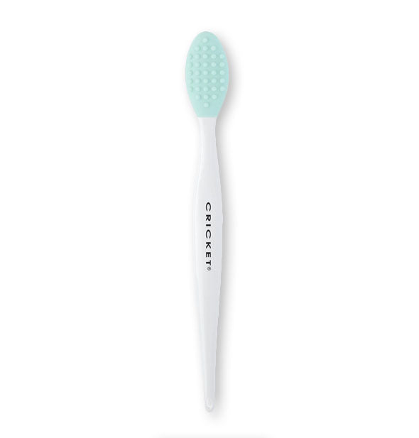 Cricket brush for lip exfoliation features a teal brush head with coarse bristle pattern