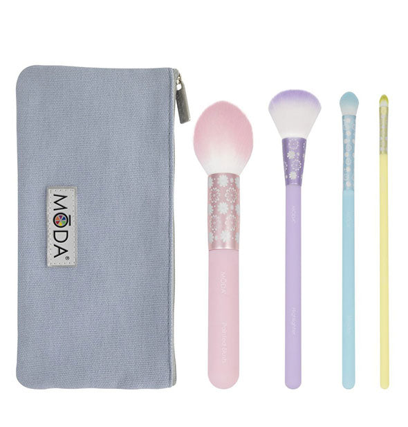 Four makeup brushes in pastel colors with printed ferrules and ombré bristles include a rectangular blue-gray Moda storage pouch